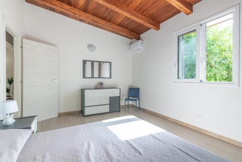 a bedroom with a bed and a desk and a window at Villa Lorenzo in Avola