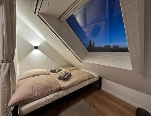 ein kleines Bett in einem Zimmer mit Fenster in der Unterkunft Ferienwohnung Dortmund - Elias - Adults Only in Dortmund