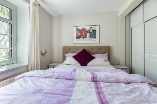 a bedroom with a purple and white bed at Denkerhof Fewo Blume des Lebens in Reußenköge