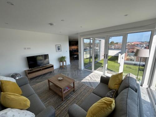 a living room with a couch and a tv at Cathedral Views in Chichester