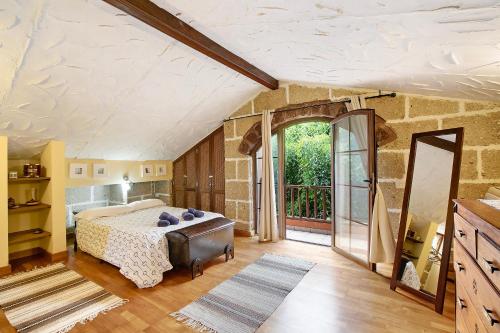 um quarto com uma cama e uma grande janela em Tegueste Entre Viñedos em Tegueste
