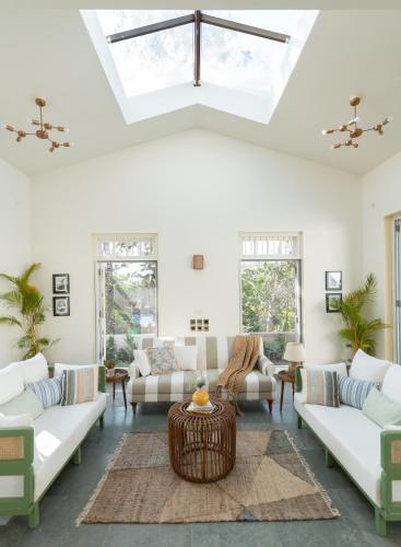 a living room with white furniture and a skylight at LohonoStays Colina Villa B in Vagator