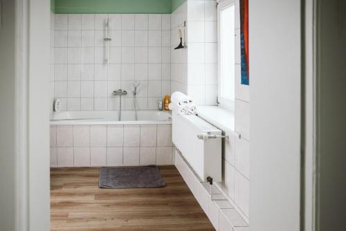 y baño con bañera y lavamanos. en Charmanter Altbau zwischen Altstadt und Klinikum mit Parkplatz en Greifswald