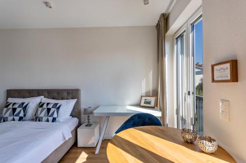 Un dormitorio con una cama y una mesa y una ventana. en Terralpin Apartments - 27qm, en Bruckmühl