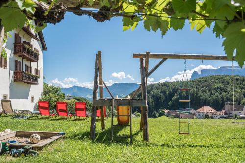 a playground in a field with chairs in the grass at Sallrain Hof Apartment 1 in Collalbo