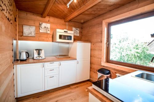a kitchen with white cabinets and a window in a tiny house at Apartament & Domek u Gabrysi in Białka Tatrzanska