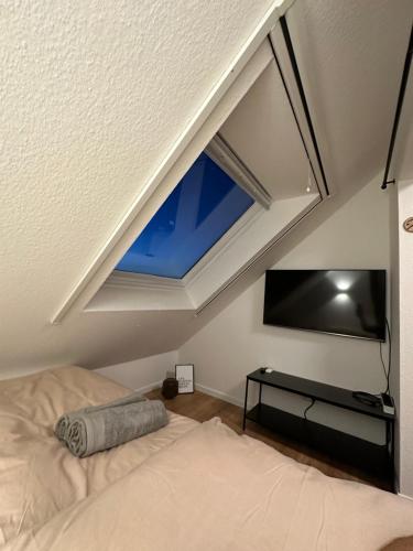 a room with a bed and a window and a tv at Ferienwohnung Dortmund - Elias - Adults Only in Dortmund