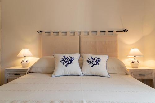 a bedroom with a white bed with two lamps at Infinite Blue Porto Cervo in Porto Cervo