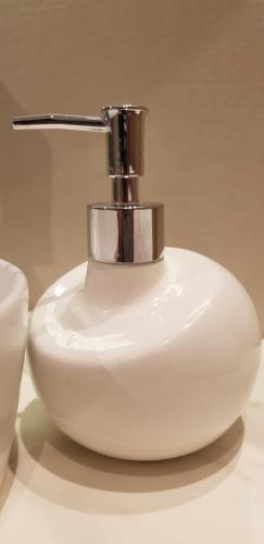 a white soap dispenser sitting on top of a sink at AppPrusnik in Ljubljana