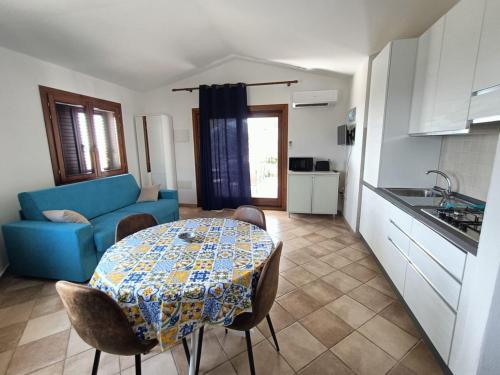 a living room with a table and a blue couch at Villa Vigna in Badesi