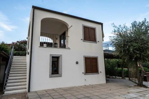a white house with a balcony and stairs at Villa Vigna in Badesi