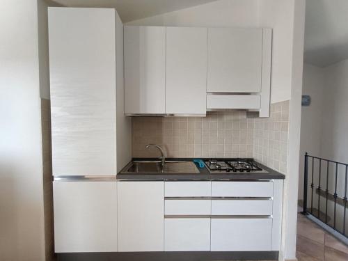 a kitchen with white cabinets and a sink at Villa Vigna in Badesi