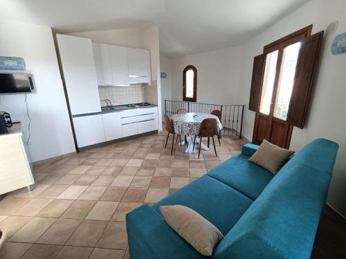 a living room with a blue couch and a table at Villa Vigna in Badesi