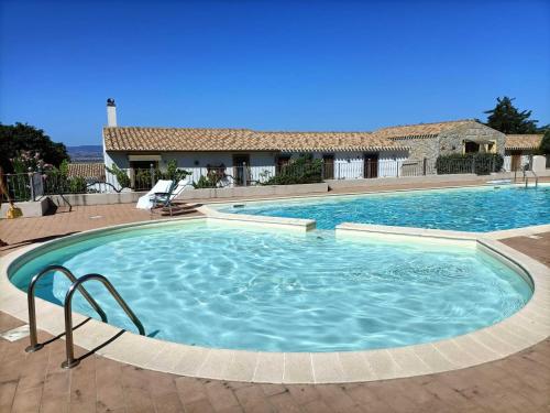 a large swimming pool with blue water at Villa Vigna in Badesi