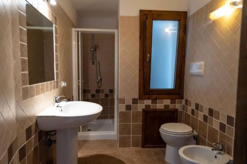 a bathroom with a sink and a toilet and a mirror at Villa Vigna in Badesi