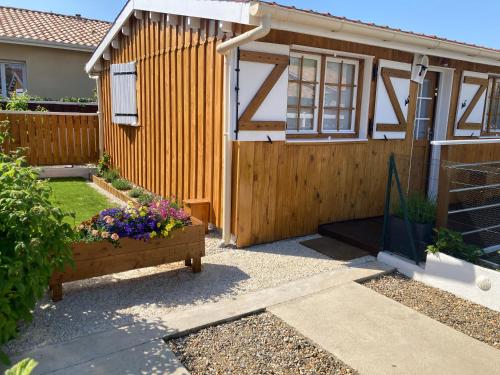 a house with a wooden fence and flowers in a garden at Chalet in Le Teich