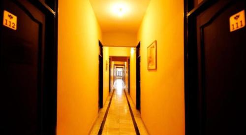 an empty hallway with yellow walls and a long corridor at Hotel Ace Plaza in Udaipur