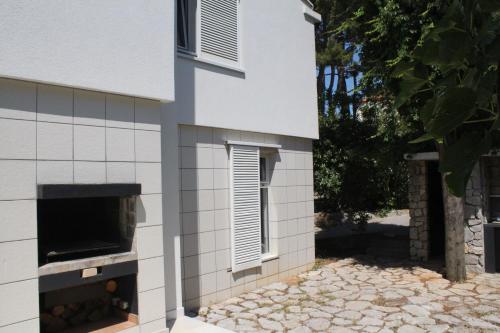 a building with a pizza oven on the side of it at Apartments PineWood Villa in Krk
