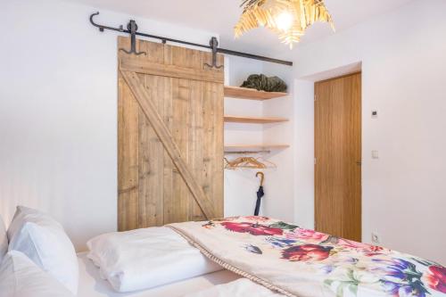 um quarto com uma porta de correr e uma cama em Eichhof Apartment Thymian em Termeno
