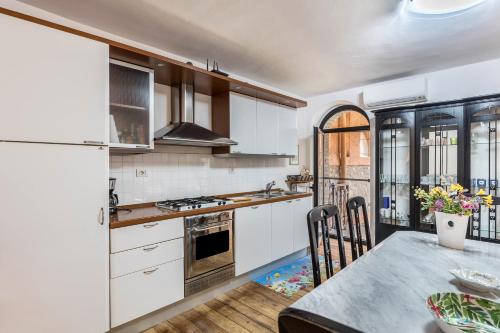 a kitchen with white cabinets and a table with a dining room at Appartamento Luna in San Felice del Benaco