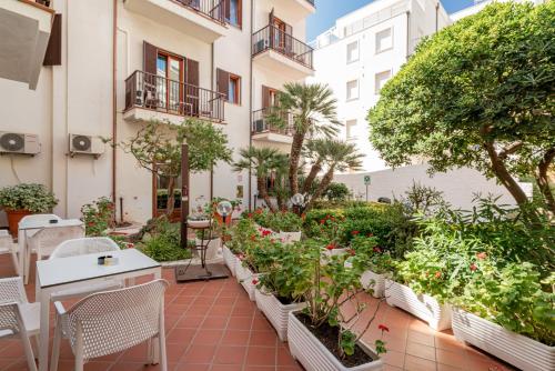 a balcony with plants and tables and chairs at Hotel El Balear in Alghero