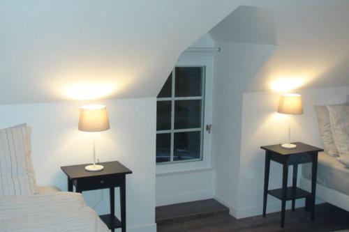 a bedroom with two end tables with lamps on them at Gite de charme à Frémainville dans le vexin in Frémainville