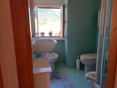 une salle de bain avec un lavabo et des toilettes et une fenêtre dans l'établissement La casetta dei pesciolini, à Sestri Levante