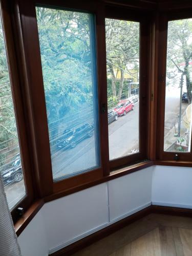 a room with three windows with a view of a street at Pousada Monte Sião in Sao Paulo