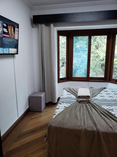 a bedroom with a bed in a room with windows at Pousada Monte Sião in Sao Paulo