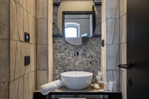 bagno con lavandino e specchio di Suite Mezzatorre a San Gimignano