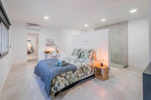 um quarto com uma cama e uma cabina de duche ao nível do chão em Bonanova 20 em Palma de Maiorca