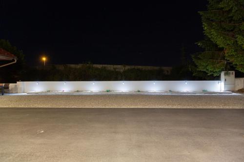 a white fence with lights on it at night at AppPrusnik in Ljubljana