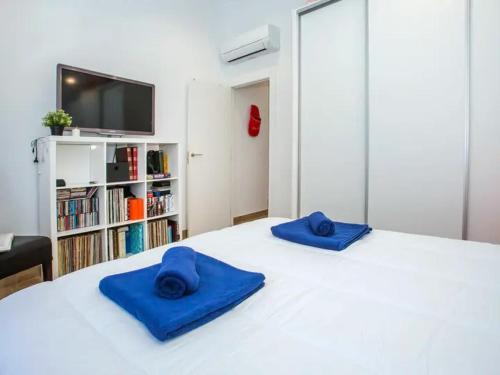 twee blauwe kussens bovenop een wit bed bij Villa Confort in Denia