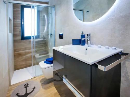 een badkamer met een wastafel, een toilet en een douche bij Villa Confort in Denia