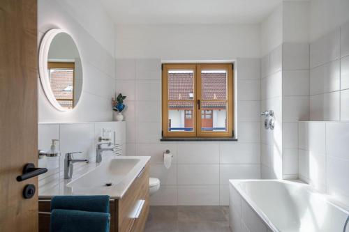 a white bathroom with a tub and a sink at Ferienwohnung Maria in Gilching
