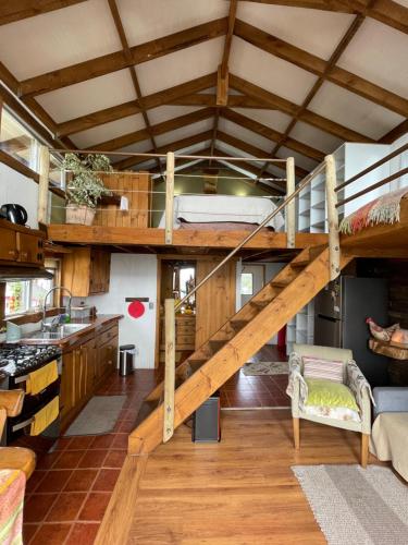 Cama elevada en habitación con cocina en Cabañas Fischer SpA, en Niebla