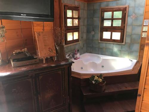 uma casa de banho com banheira e uma televisão num quarto em בקתות עץ סקנדינביות במטולה em Metulla