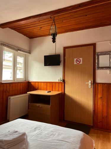 a bedroom with a bed and a tv on the wall at Casa Aramis in Azuga
