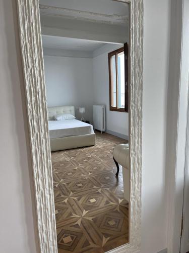 a mirror reflecting a bedroom with a bed in a room at The B Collection - San Marco Riva schiavoni in Venice