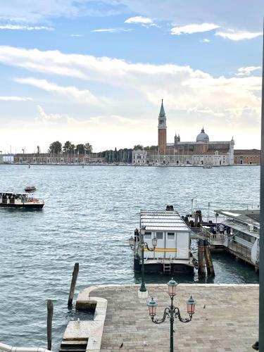 a dock with a boat in the water next to a city at The B Collection - San Marco Riva schiavoni in Venice