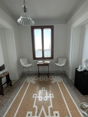 a room with two chairs and a table and a rug at The B Collection - San Marco Riva schiavoni in Venice