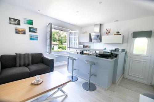 eine Küche und ein Wohnzimmer mit einer Couch und einem Tisch in der Unterkunft Sable et Reflets - T2 - Centre ville d'Hossegor in Soorts-Hossegor