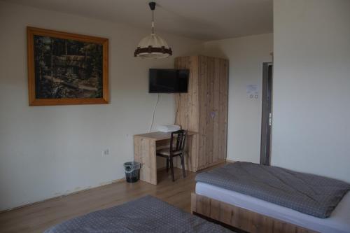 - une chambre avec un lit et un bureau avec une télévision dans l'établissement BB Gore, à Dol pri Hrastniku