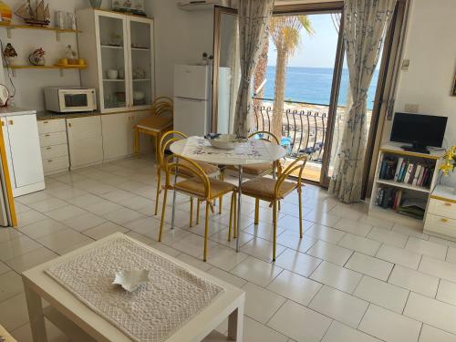 cocina con mesa y vistas al océano en Casa del Sole en Letoianni