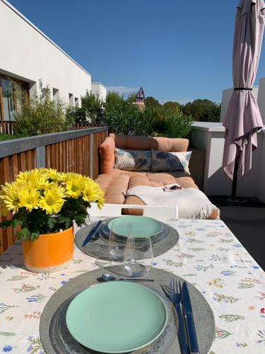 una mesa con una placa de cristal en el patio en Appartement terrasses proche Orly & Paris, en Chevilly-Larue