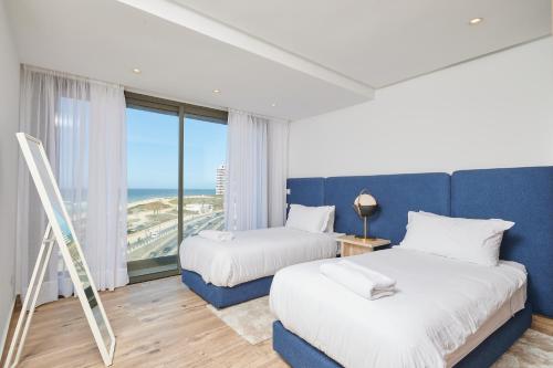 2 łóżka w pokoju z widokiem na ocean w obiekcie Apartment Sea View B22 -Mosquée Hassan II By TheCasaEdition w mieście Casablanca