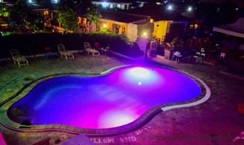 una gran piscina por la noche con luces moradas en Galaxy Resort Kitengela en Athi River