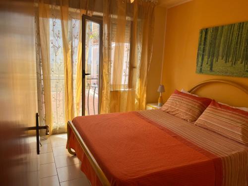 a bedroom with a bed and a large window at Casa del Sole in Letojanni
