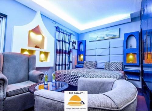 Athi RiverにあるGalaxy Resort Kitengelaのベッド、ソファ、テーブルが備わるホテルルームです。