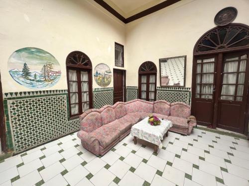 ein Wohnzimmer mit einem Sofa und einem Tisch in der Unterkunft HOTEL DU PARC in Fès